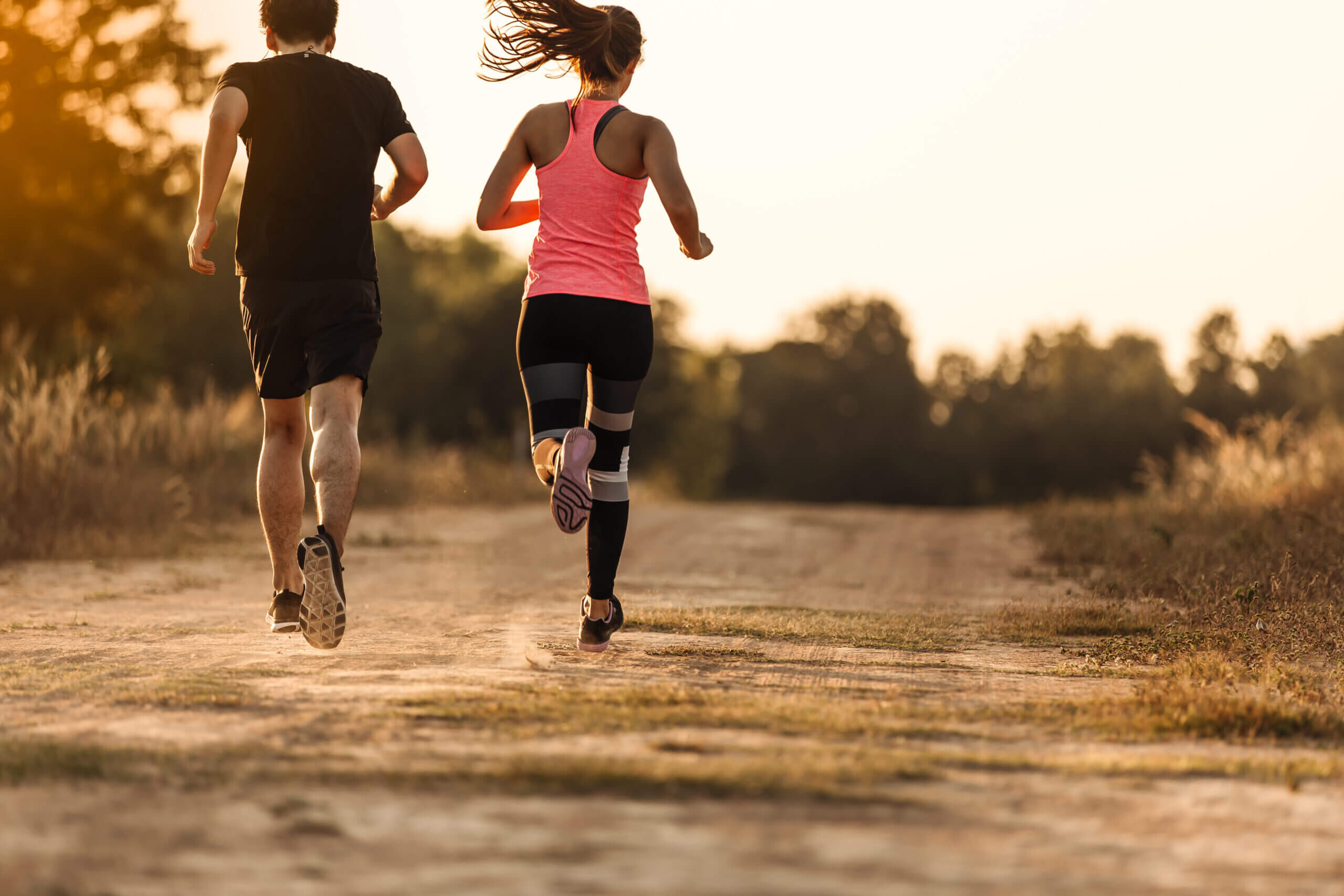 young couple running forest trail scaled